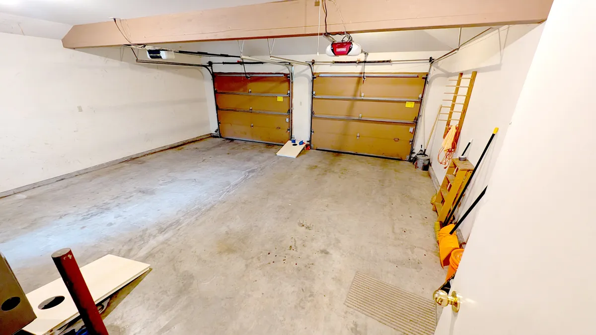 The image looks into the garage area, highlighting practical garage doors, a workbench, and organized storage items. This space is ready for storing outdoor gear, bikes, kayaks, and adventure supplies after a day exploring Sunriver.
